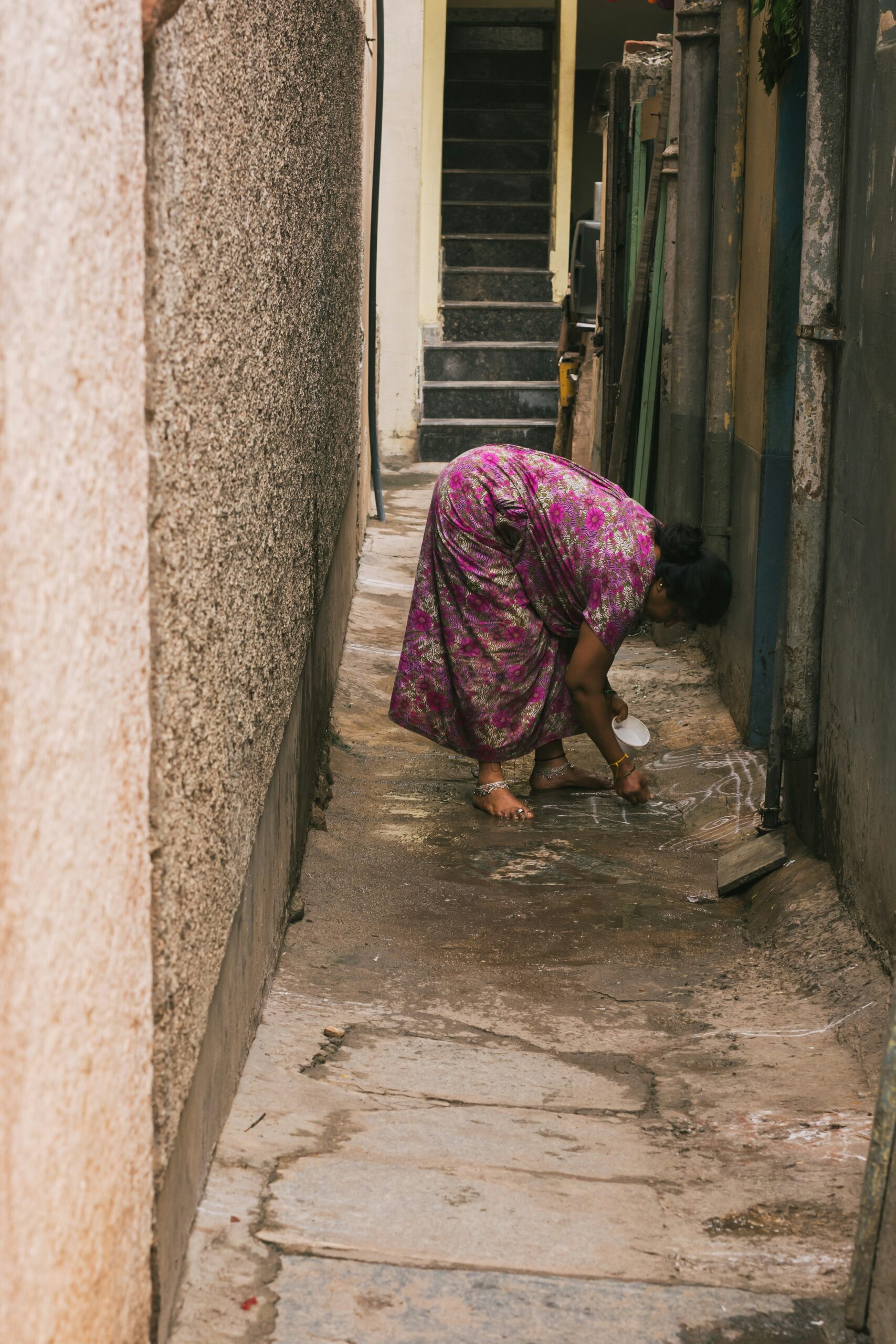 a woman bending down to pick up something from the ground